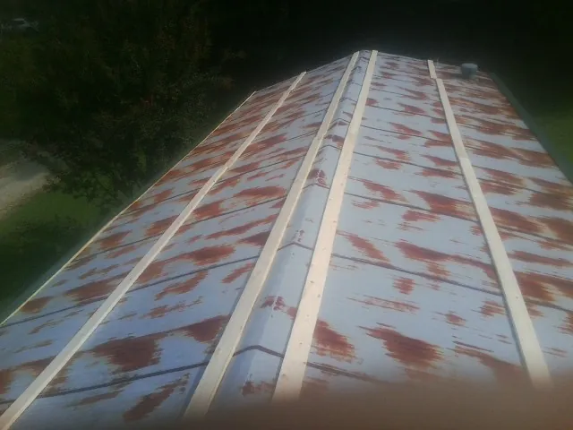 Rusted metal roof panels with new wood purlins before replacement — Storm Damage Roof Repair in Lavallette by Roofing Brothers
